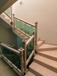 Escaleras interiores con barandales de cristal y estructura met&aacute;lica en el edificio de tres niveles en Toluca.