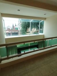 Ventanales panor&aacute;micos con barandal de cristal en el segundo nivel del edificio en venta en Toluca.