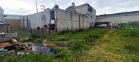 ista desde el acceso del terreno en venta en Cuendo, con &aacute;rea despejada y construcci&oacute;n auxiliar.